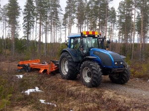 Traktori metsätienpohjan jyrsintätyössä